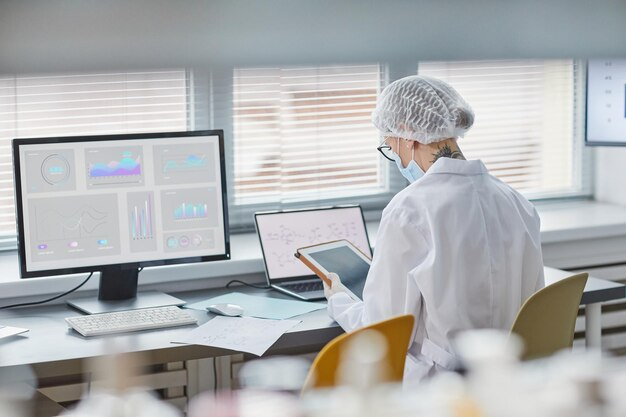 Doctor working on a laboratory computer and tablet