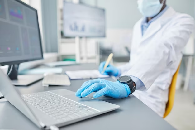 Doctor in front of a laptop and computers