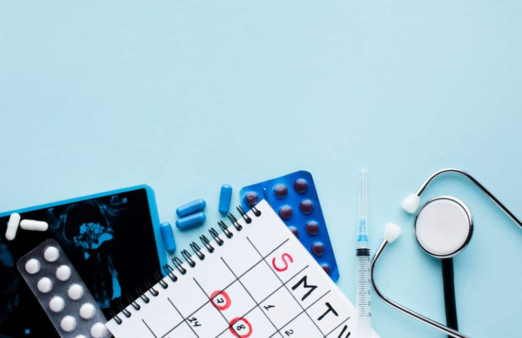 A medical-themed flat lay with pills, a calendar, and diagnostic imaging